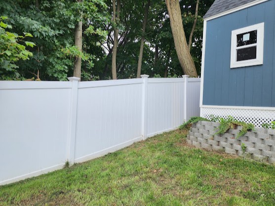 Beautiful new white vinyl privacy fence completing the yard
